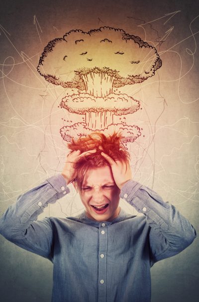 Desperate teenage boy, hands to head, messing up hair and screaming. Head explosion concept, mental health problems, anxiety and headache feeling. Losing mind function, dementia disease and migraine.